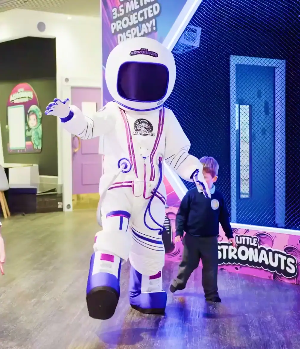 Astronaut mascot interacting with child in indoor play area
