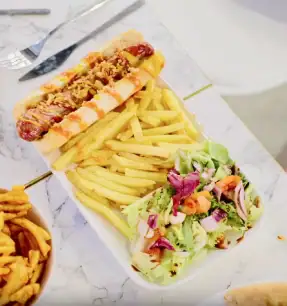 Kids meal with hot dog fries and salad in indoor play center cafe