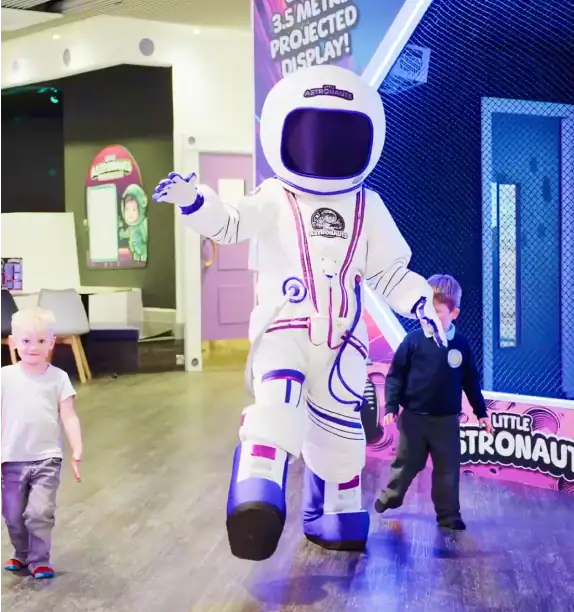 Mascot astronaut interacting with kids at indoor soft play center