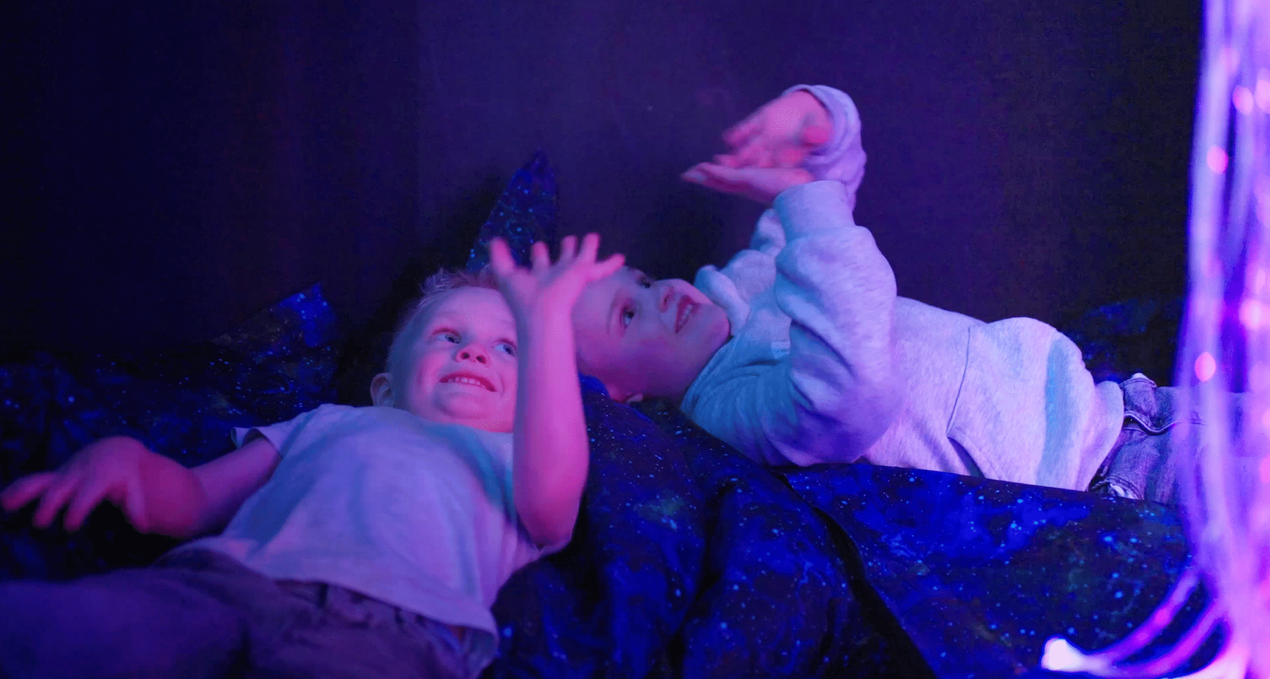 Children enjoying sensory room with glowing lights in immersive play experience