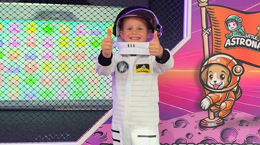 Child wearing astronaut costume dress up activity in indoor play center