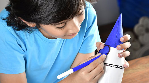 Child decorating rocket craft during educational visit learning activity