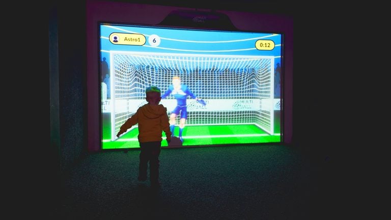 A child playing football on the giant Multiverse interactive screen